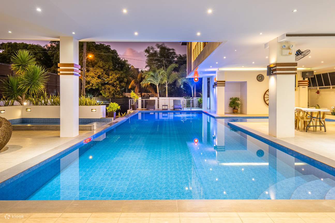 Una piscina cubierta azul con pilares blancos alrededor