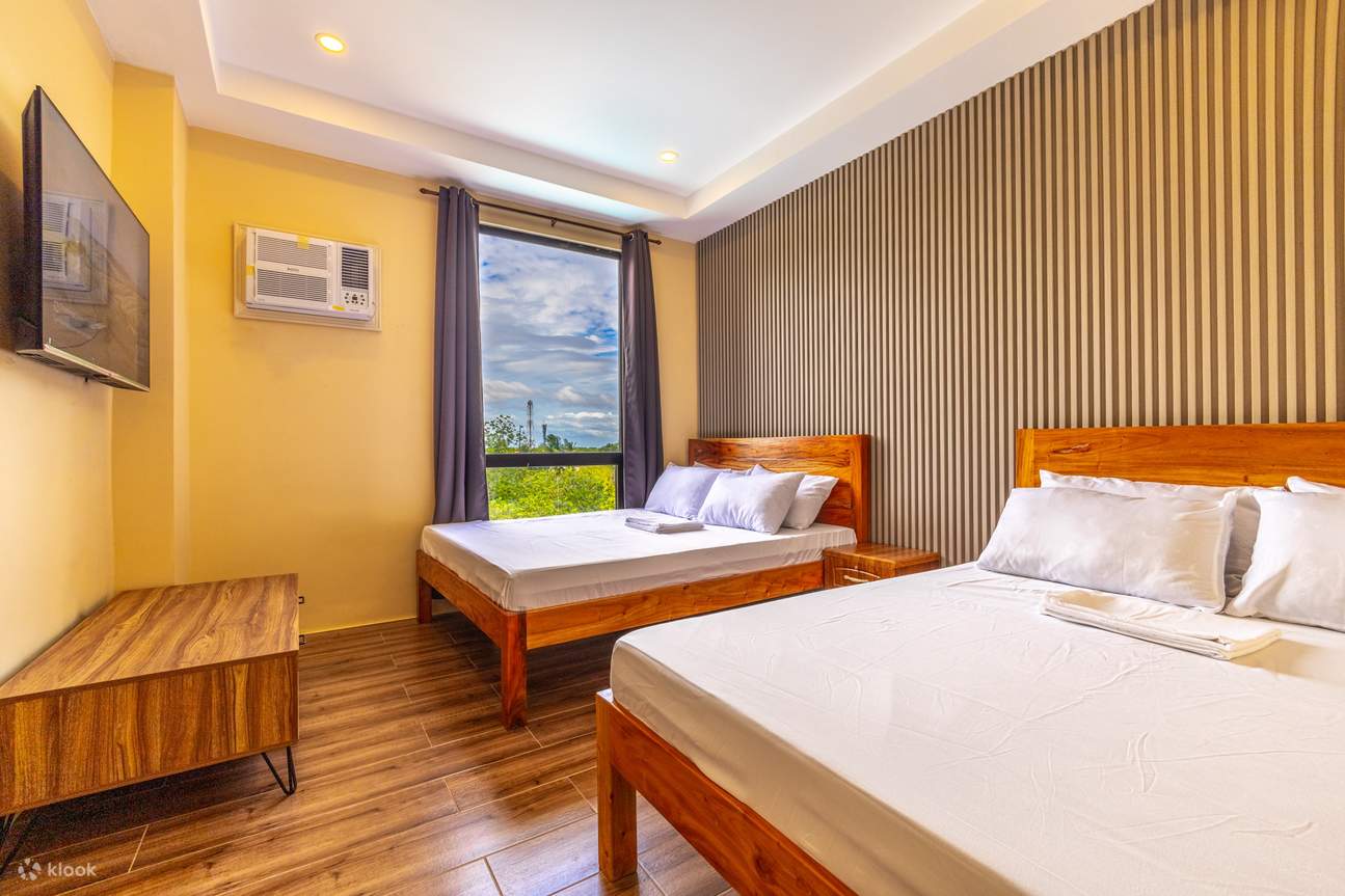 침실에는 침대 2개, TV, 에어컨이 완비되어 있으며, 밝은 색상의 벽으로 포인트를 주었습니다.