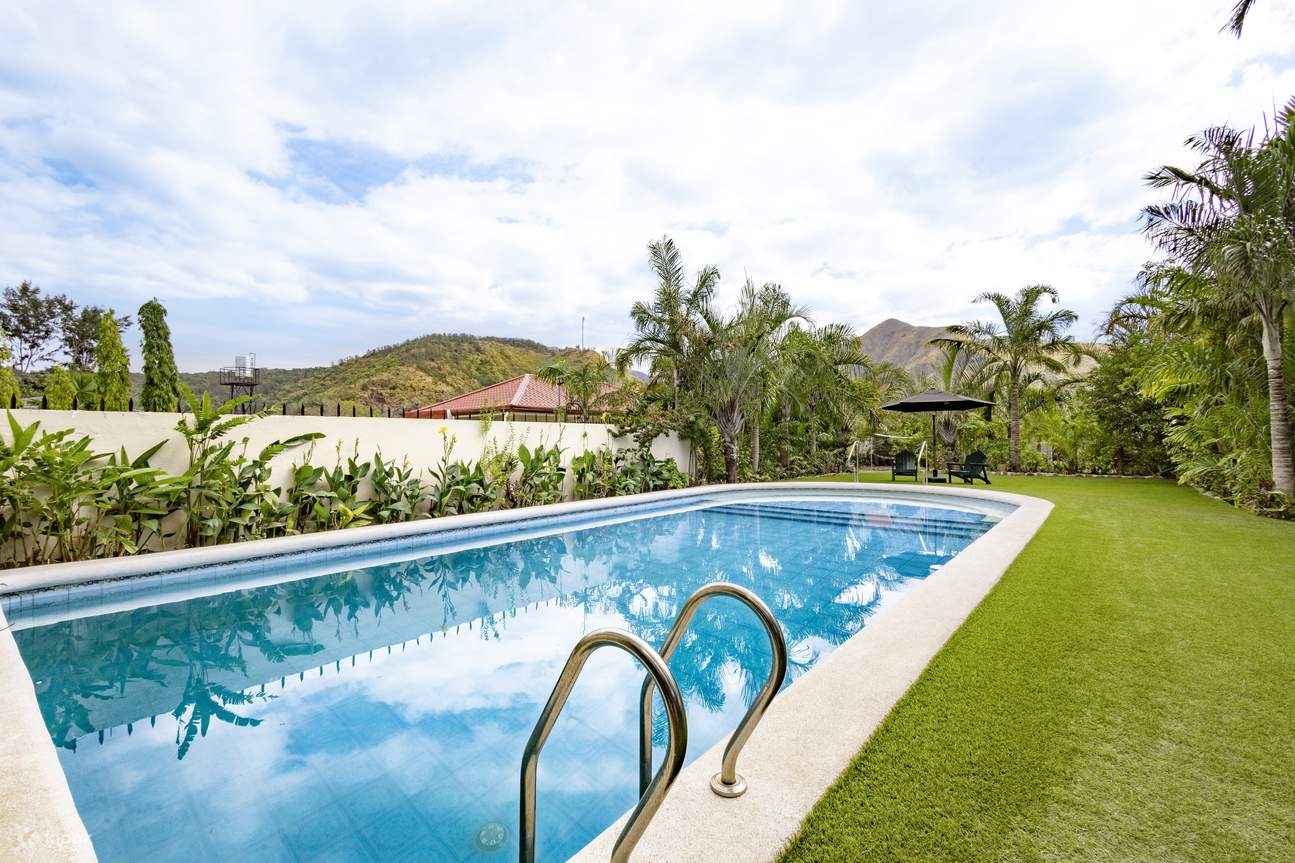 Piscina alargada rodeada de césped