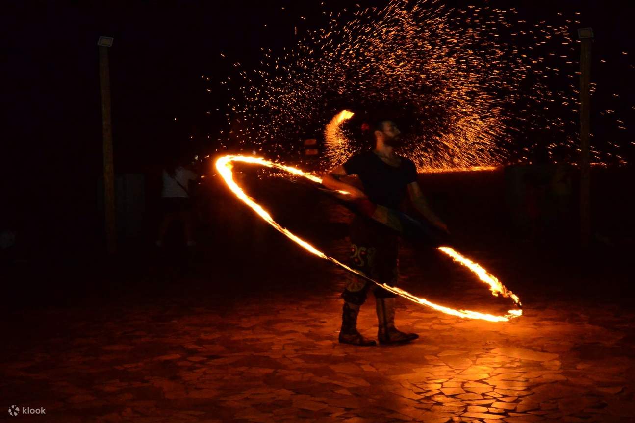 男性の周りで火の輪を使ったファイヤーショー