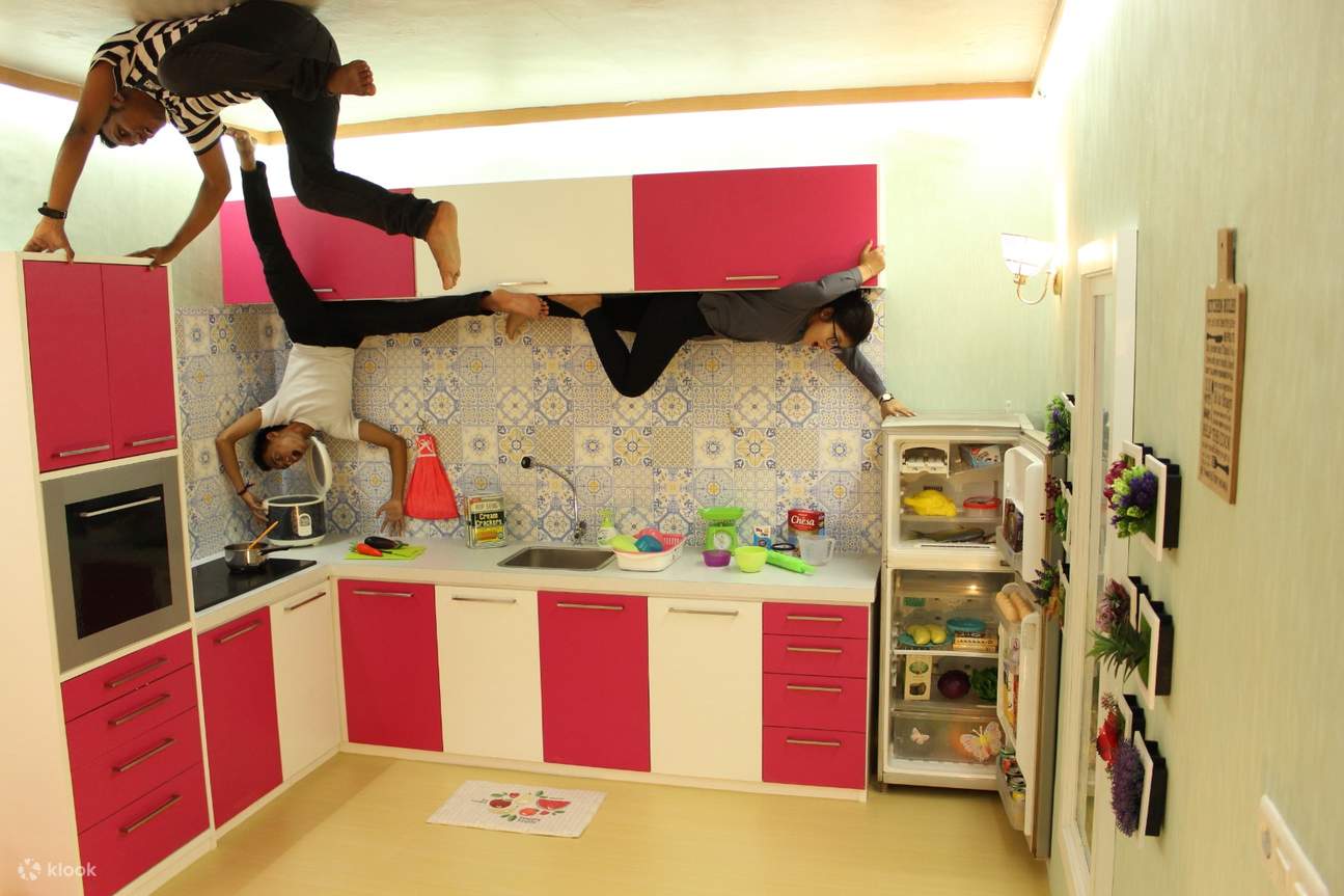 2 guys  and 1 girl posing upside down inside a kitchen themed space