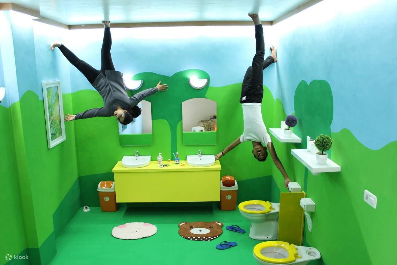 a couple posing upside down inside a bathroom themed space