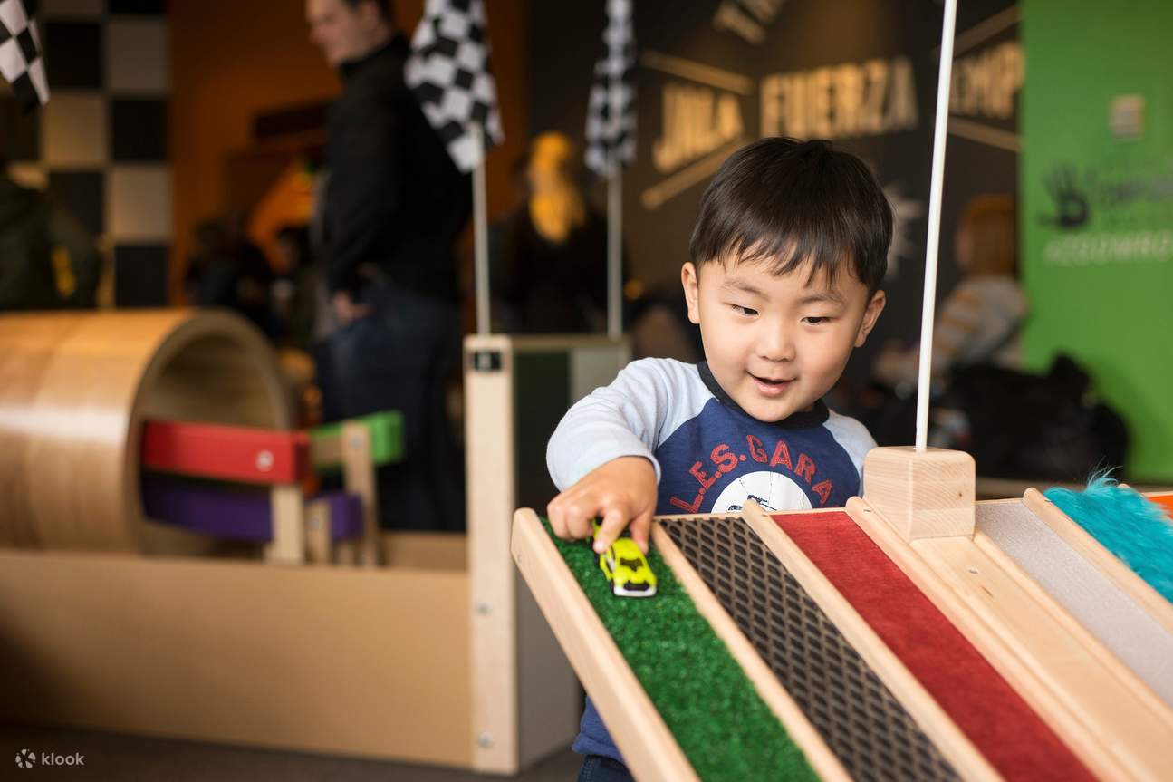 おもちゃの車と線路で遊ぶ小人