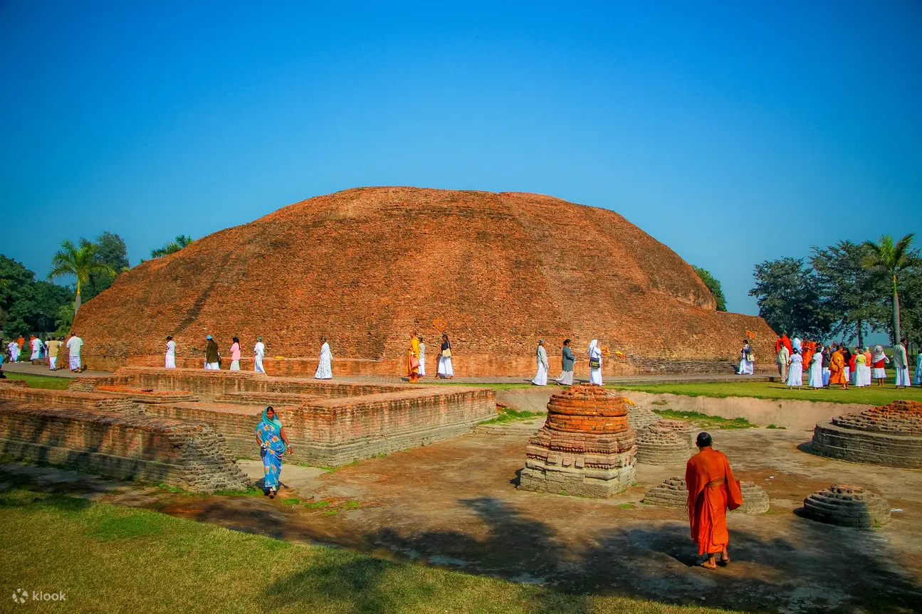 佛教僧侶站在蘭巴爾佛塔（The Ramabhar Stupa）前，在拘屍那迦朝拜佛陀的火葬地。