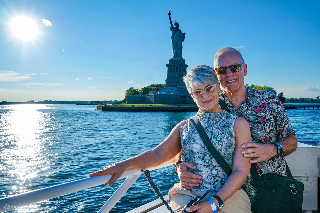 Un couple partage un moment ensemble, créant des souvenirs avec la Statue de la Liberté qui se dresse derrière eux