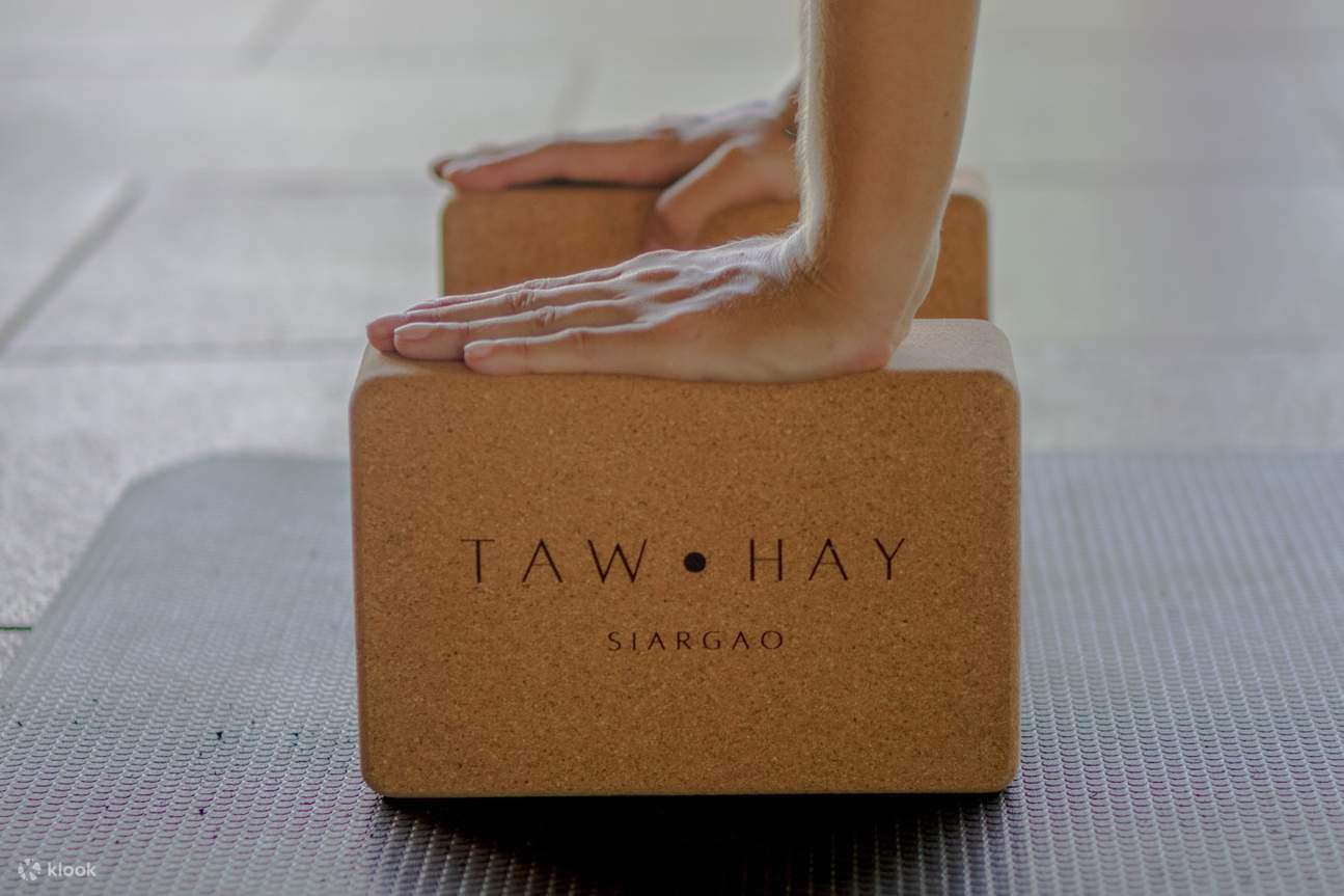 Persona haciendo ejercicio en un bloque de fitness con taw hay siargao en él.