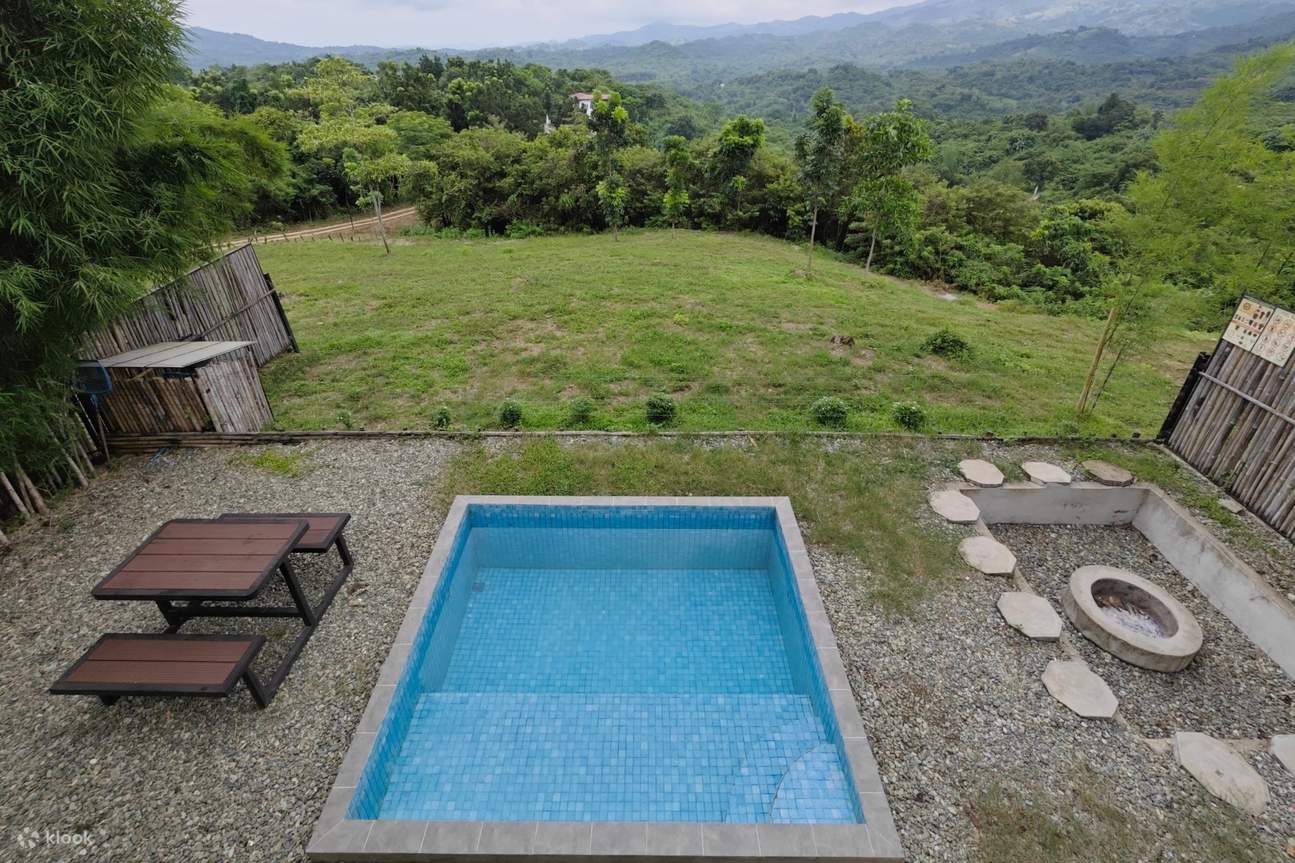 Piscine extérieure avec une table et un feu de camp à côté