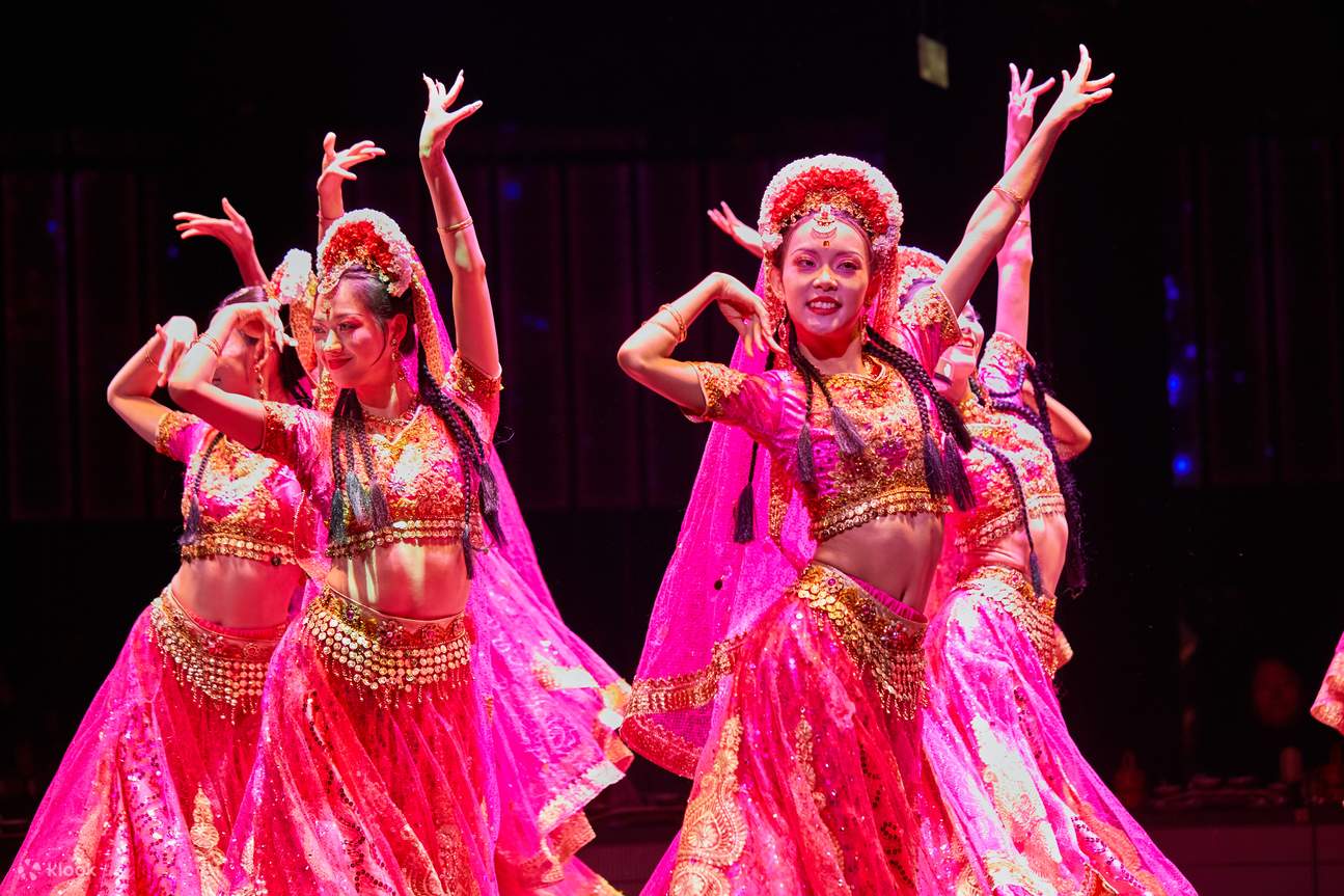 Sekumpulan penari yang memakai gaun merah terang dan tudung tulle ringan berputar dengan anggun di atas pentas.