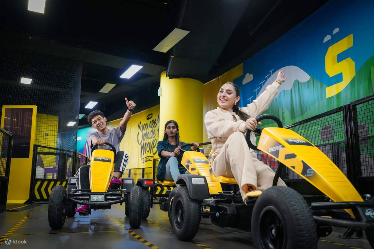 persone che guidano un'auto a pedali nel Superpark di Kuala Lumpur