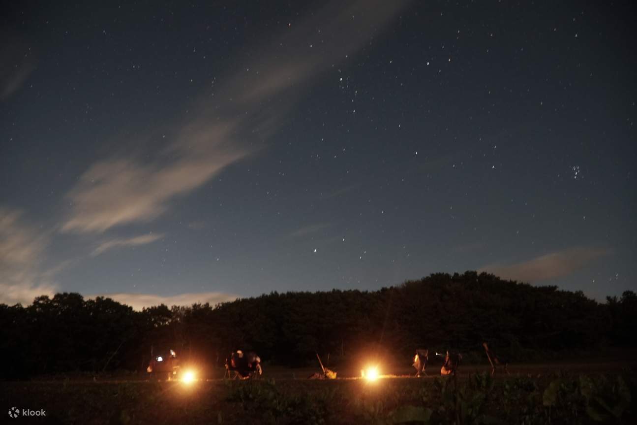 Campeggio e cielo notturno con stelle visti dalla spiaggia
