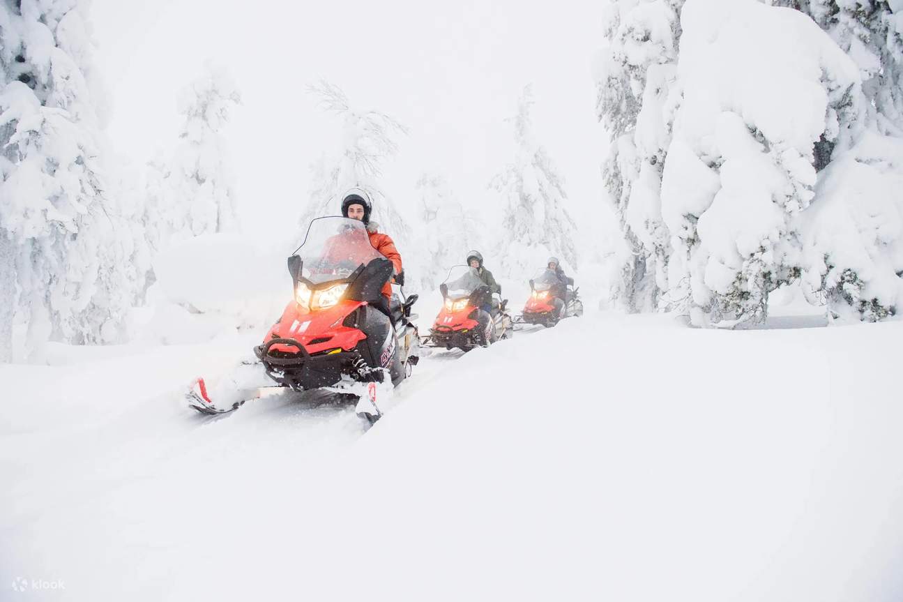 Neve farinosa mentre persone guidano una motoslitta