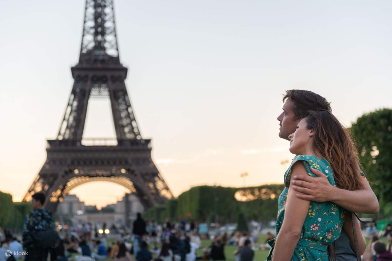 Couple prenant des photos devant la Tour Eiffel