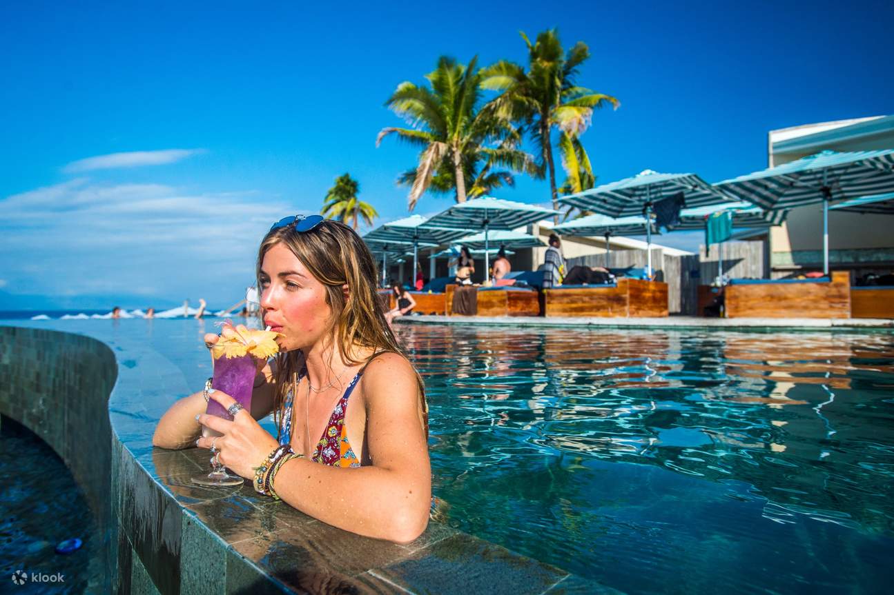 Una donna che sorseggia un cocktail in piscina