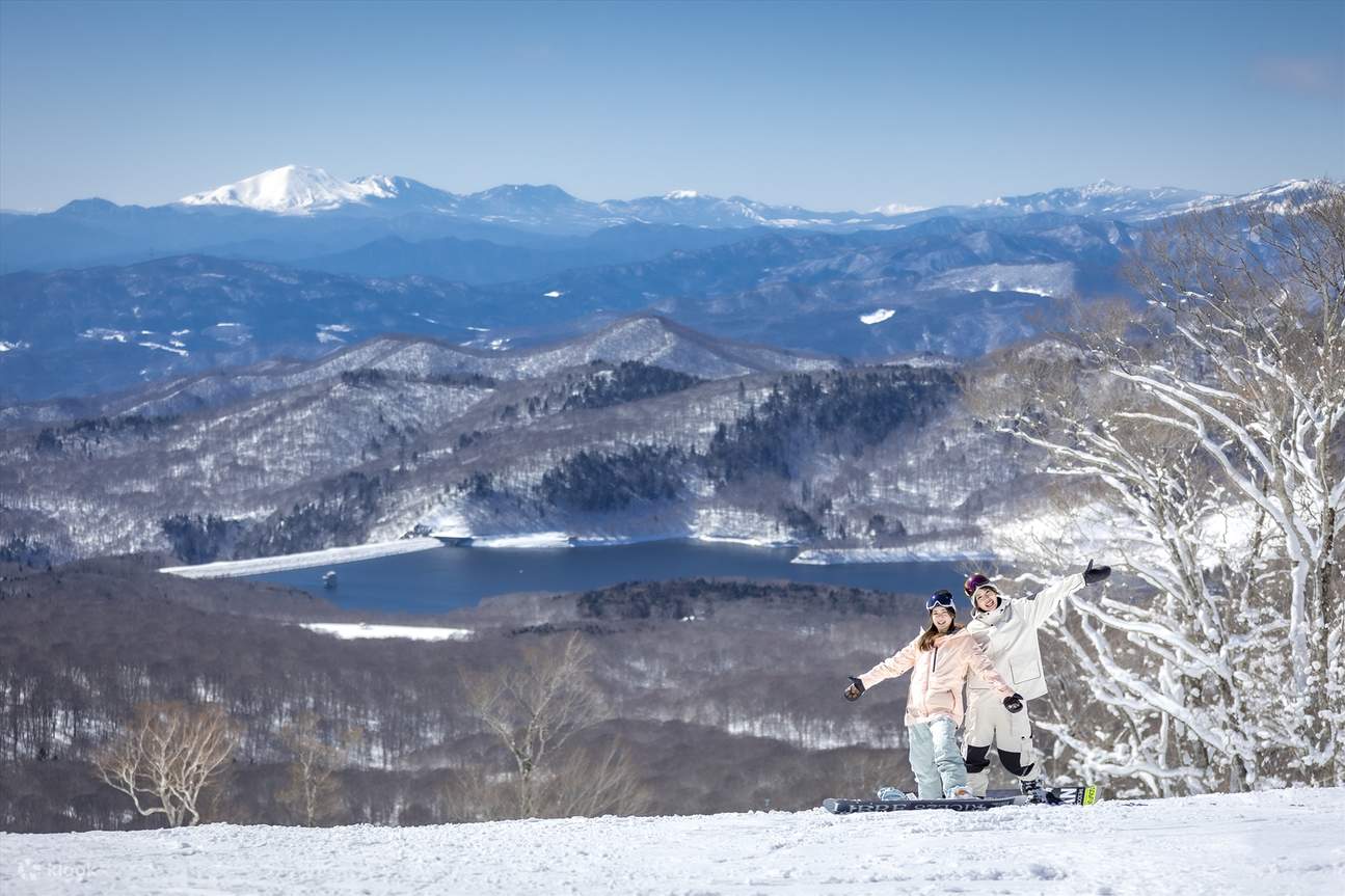 Dua orang mengambil gambar di resort ski