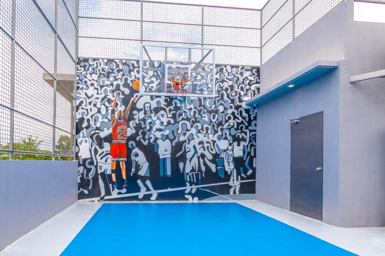 Basketball court with mural on wall, featuring vibrant colors and unique design