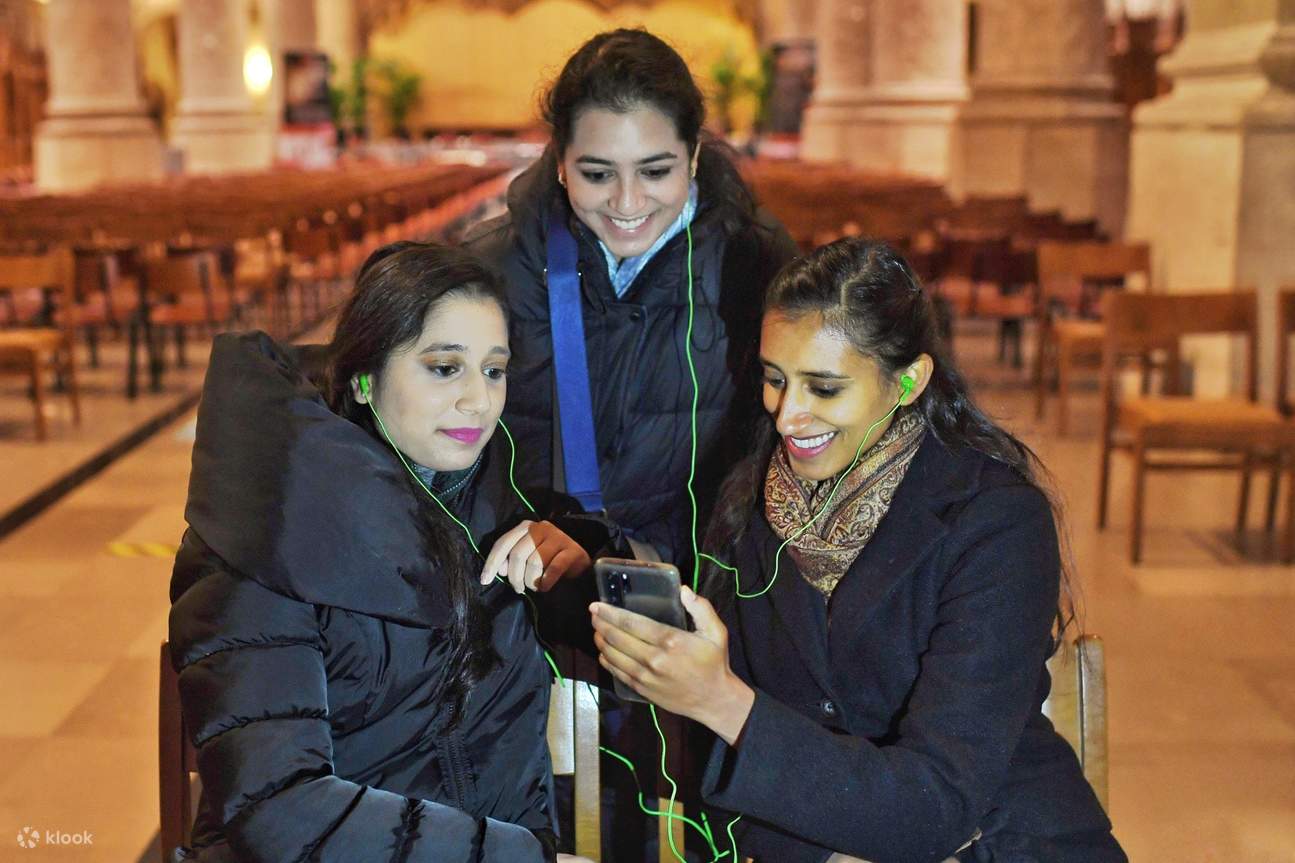 женщины слушают аудиогид внутри собора Нотр-Дам