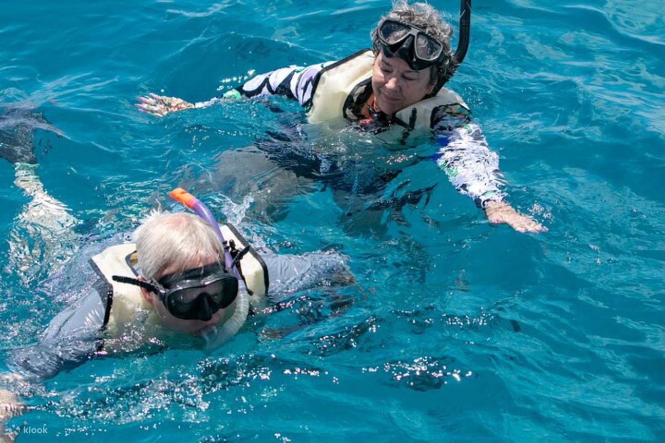 Pasangan lansia menikmati snorkeling bersama, berbagi petualangan bawah laut yang ajaib
