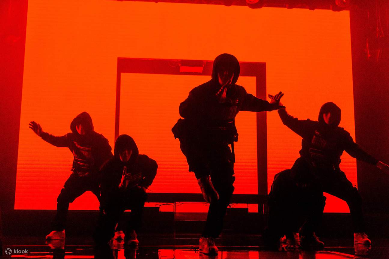 Группа людей, танцующих в оранжевом свете