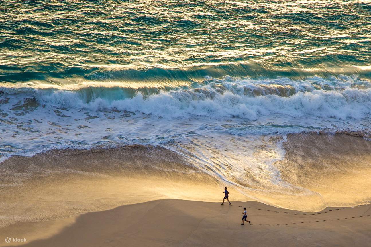 Menschen laufen am Meer entlang
