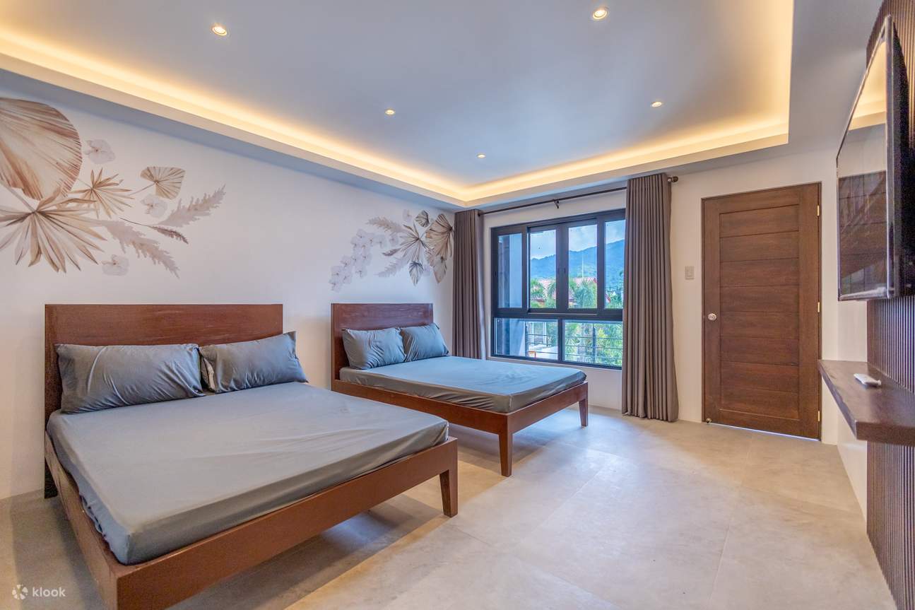 A bedroom featuring two beds with grey sheets