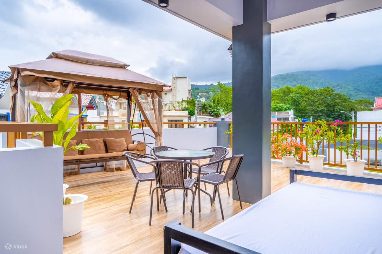 Veranda con vista su una montagna con divano a dondolo e tavolo per cinque