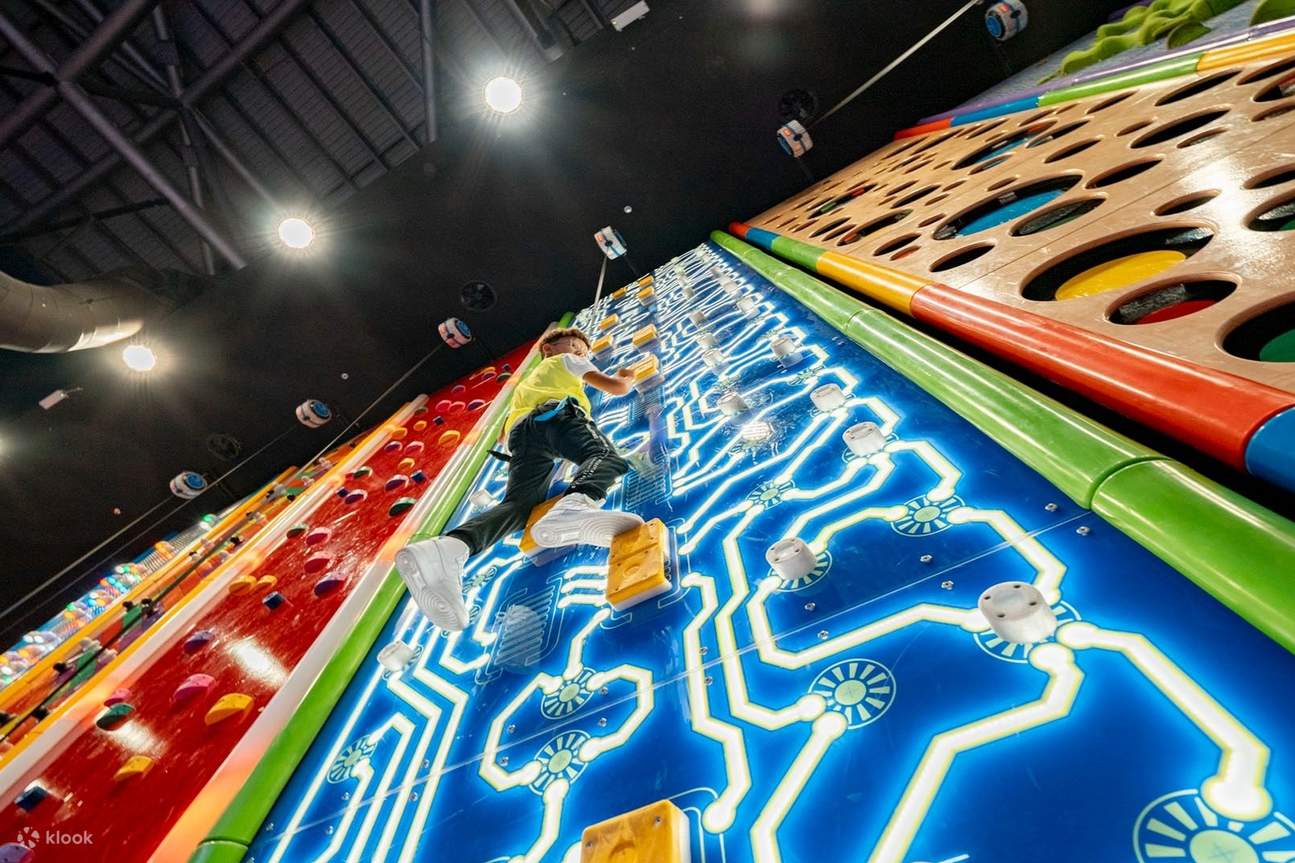 一個孩子正在攀爬一面色彩繽紛的牆壁