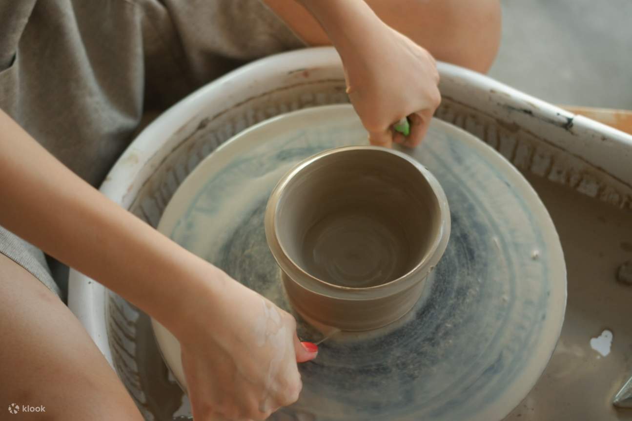 Dua orang kanak-kanak mengeratkan hubungan sambil membuat tembikar