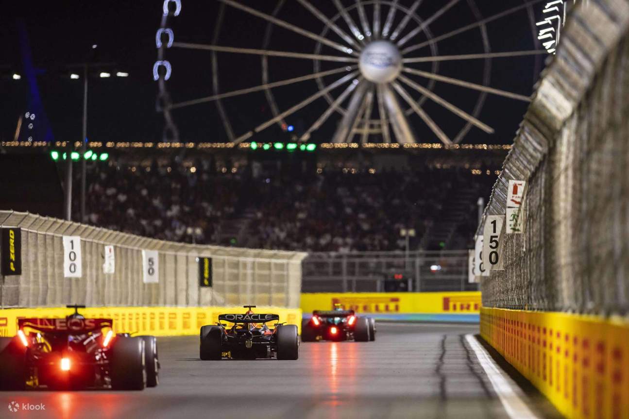 Night racing under the lights, with the track and Ferris wheel creating a stunning backdrop
