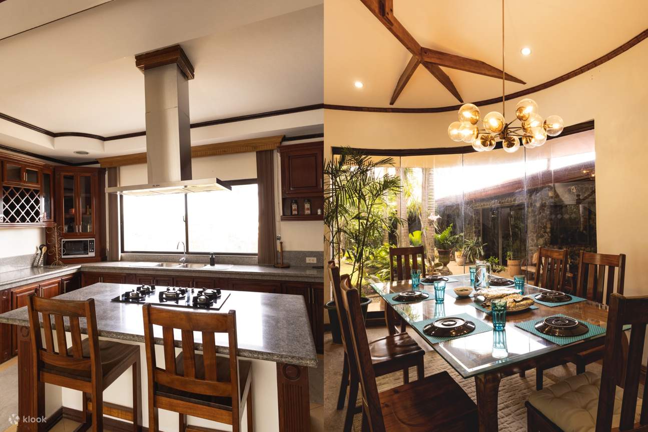 Cocina con extractor y mesa central, y una mesa de comedor rodeada de sillas