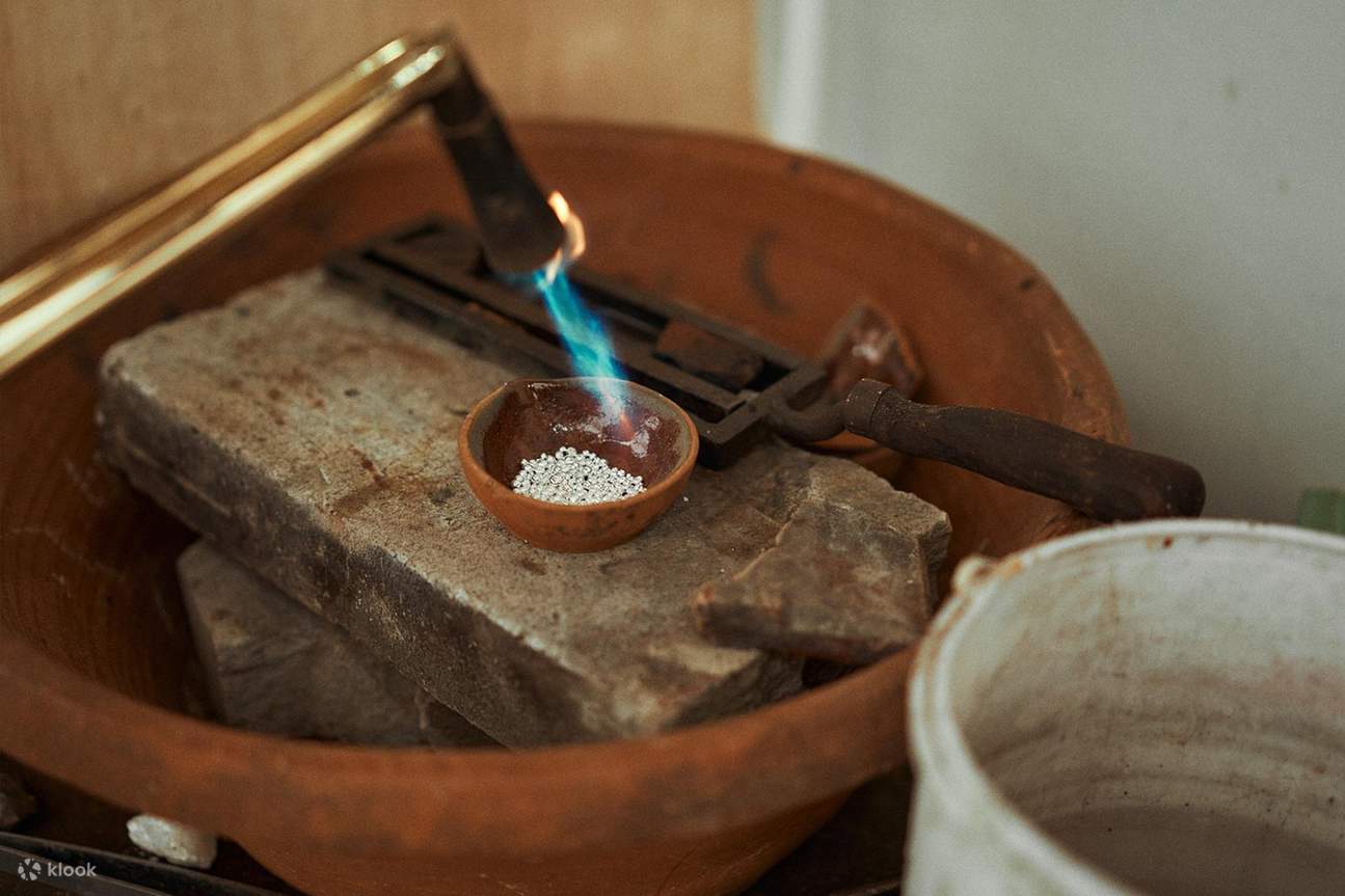 銀のビーズが青い炎で熱せられています。これは、非常に高い精度が要求されるジュエリー製作工程の初期段階です。