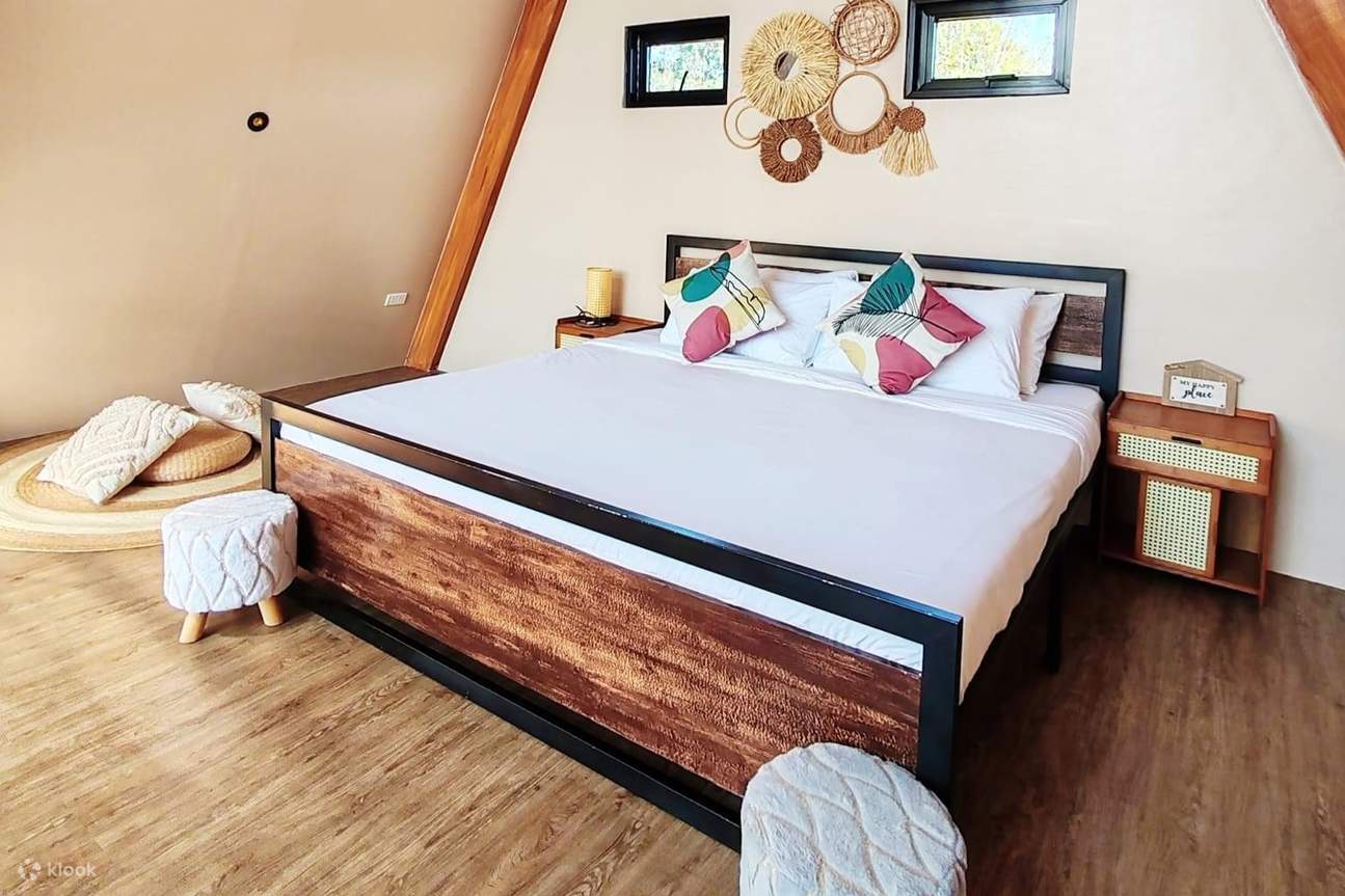 Phòng ngủ có giường trắng và hai ghế đẩu