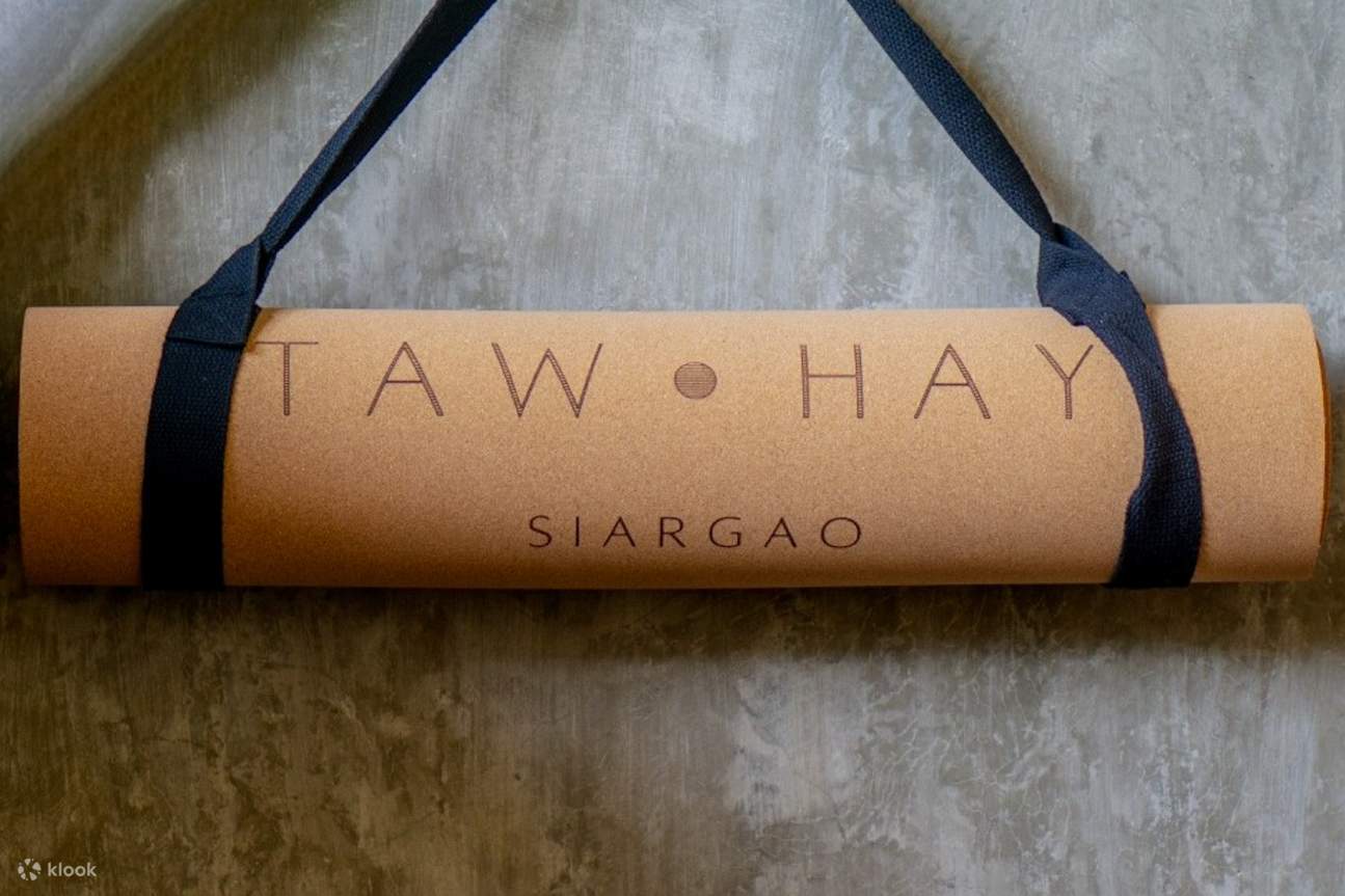 tappetino da yoga appeso al muro con la scritta taw hay siargao