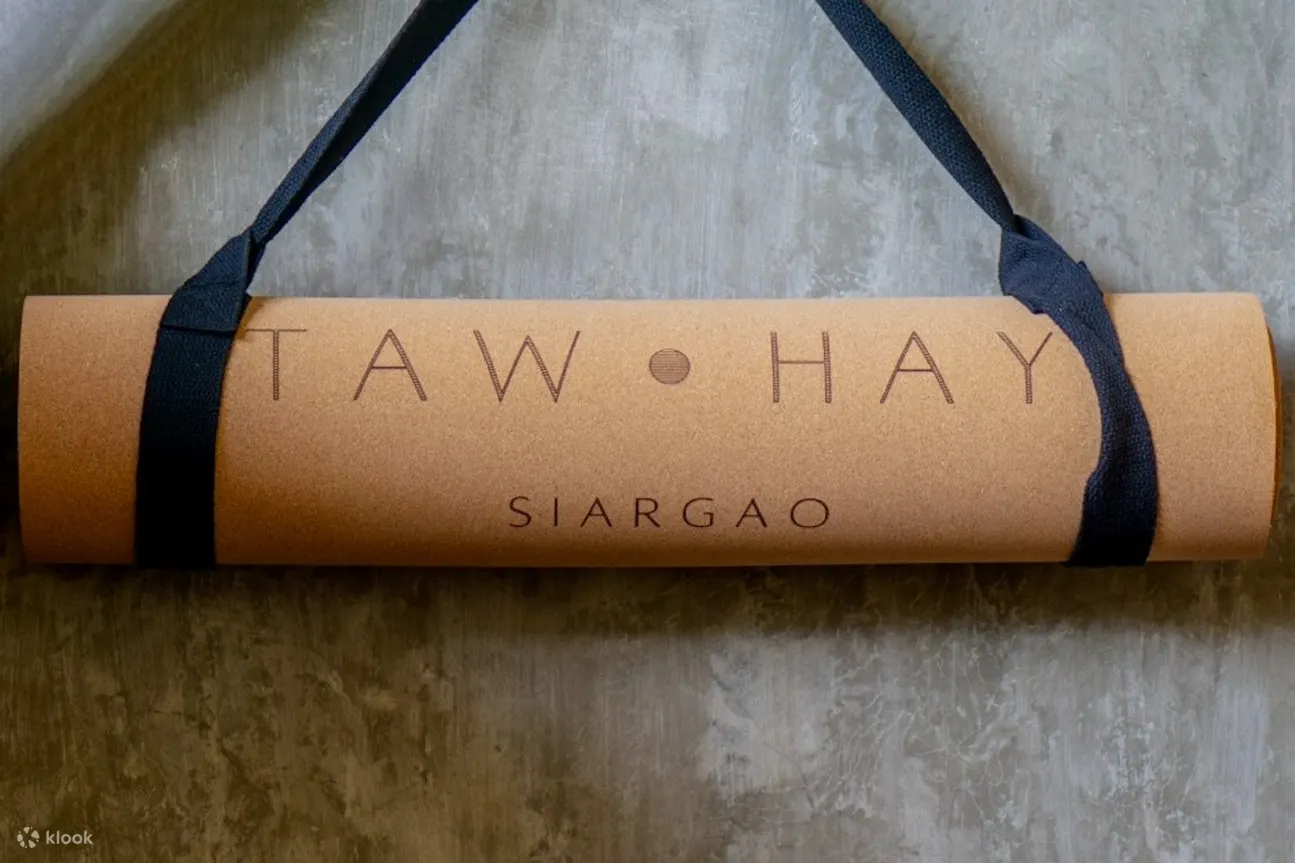 墙上挂着一张印有「taw hay siargao」字样的瑜珈垫