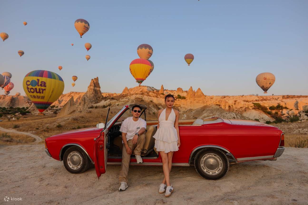 Séance photo en montgolfière au lever du soleil en voiture de collection en Cappadoce 
