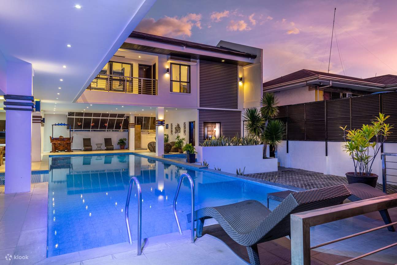 Una piscina al crepuscolo con sedie a sdraio a bordo piscina