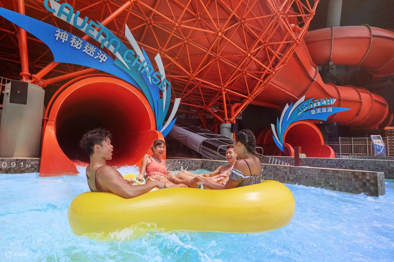 Four people are enjoying a water ride on a yellow raft exiting the Guergosia water slide at Ocean Park Hong Kong Water World attraction 2025.