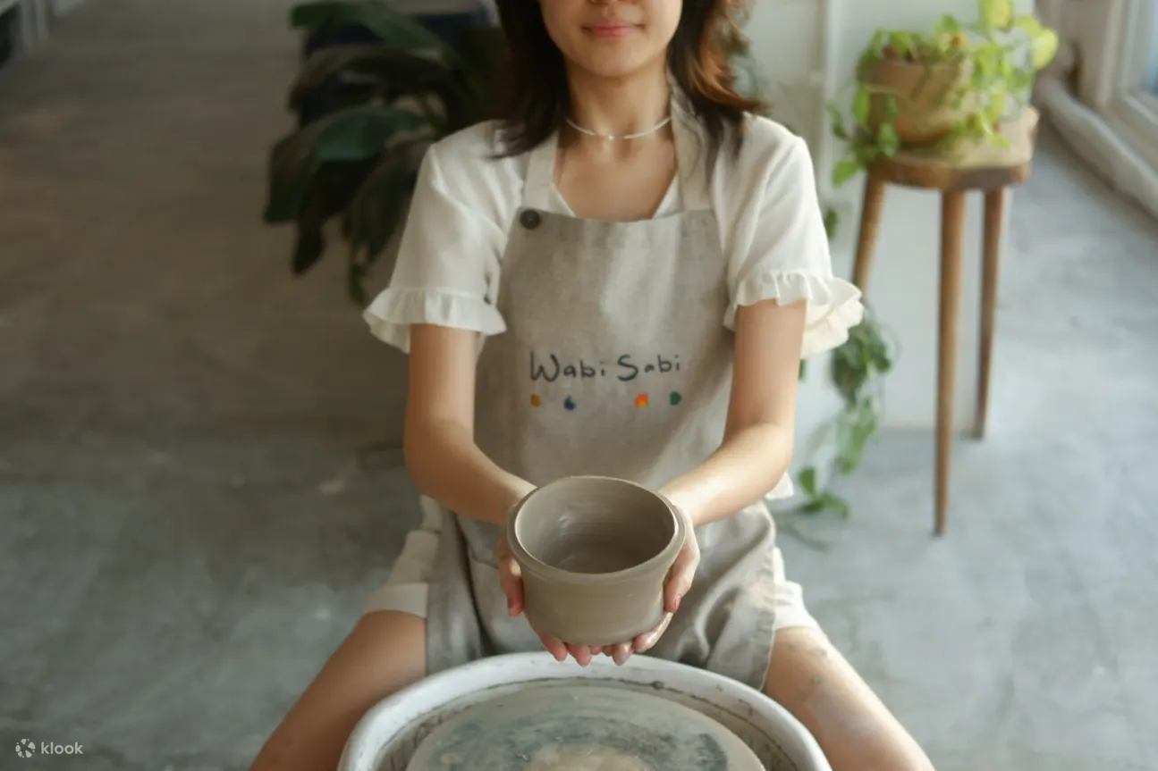 女人举着自己制作的花盆