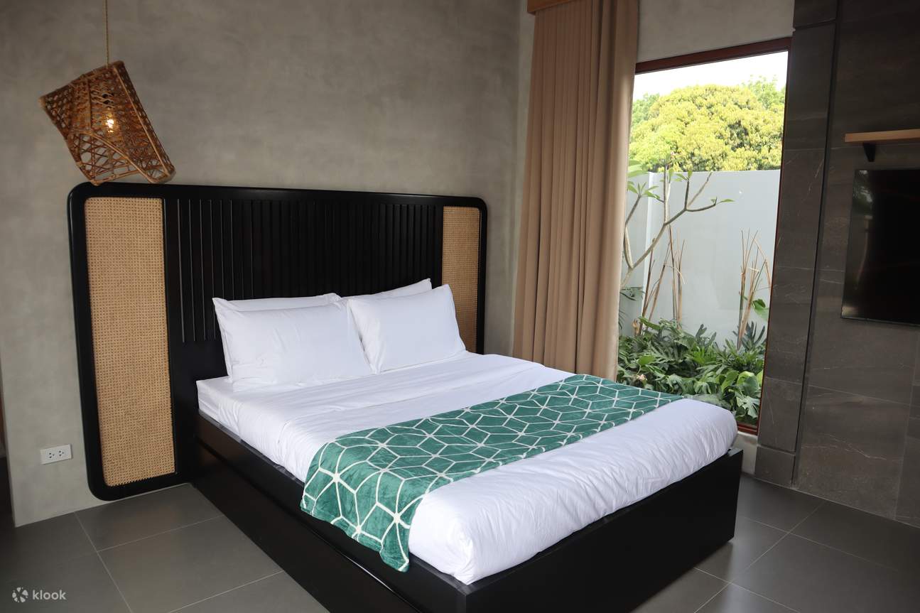 白いシーツと緑と黒の枕が付いたベッド