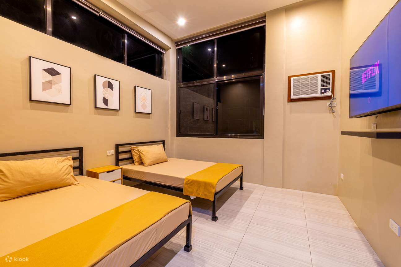 Dormitorio con dos camas y un televisor