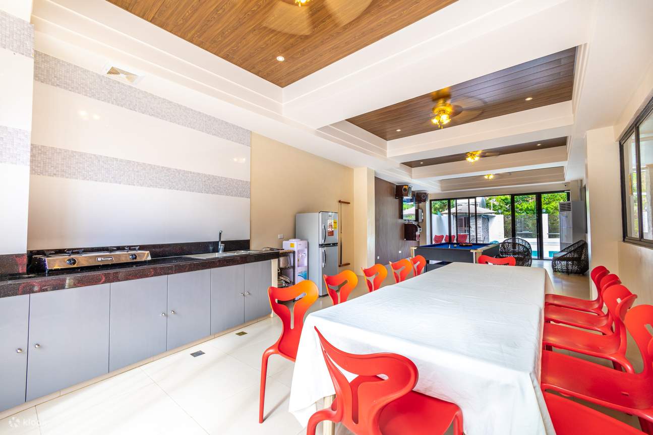 Ruang makan dengan kerusi merah, meja putih dan kaunter