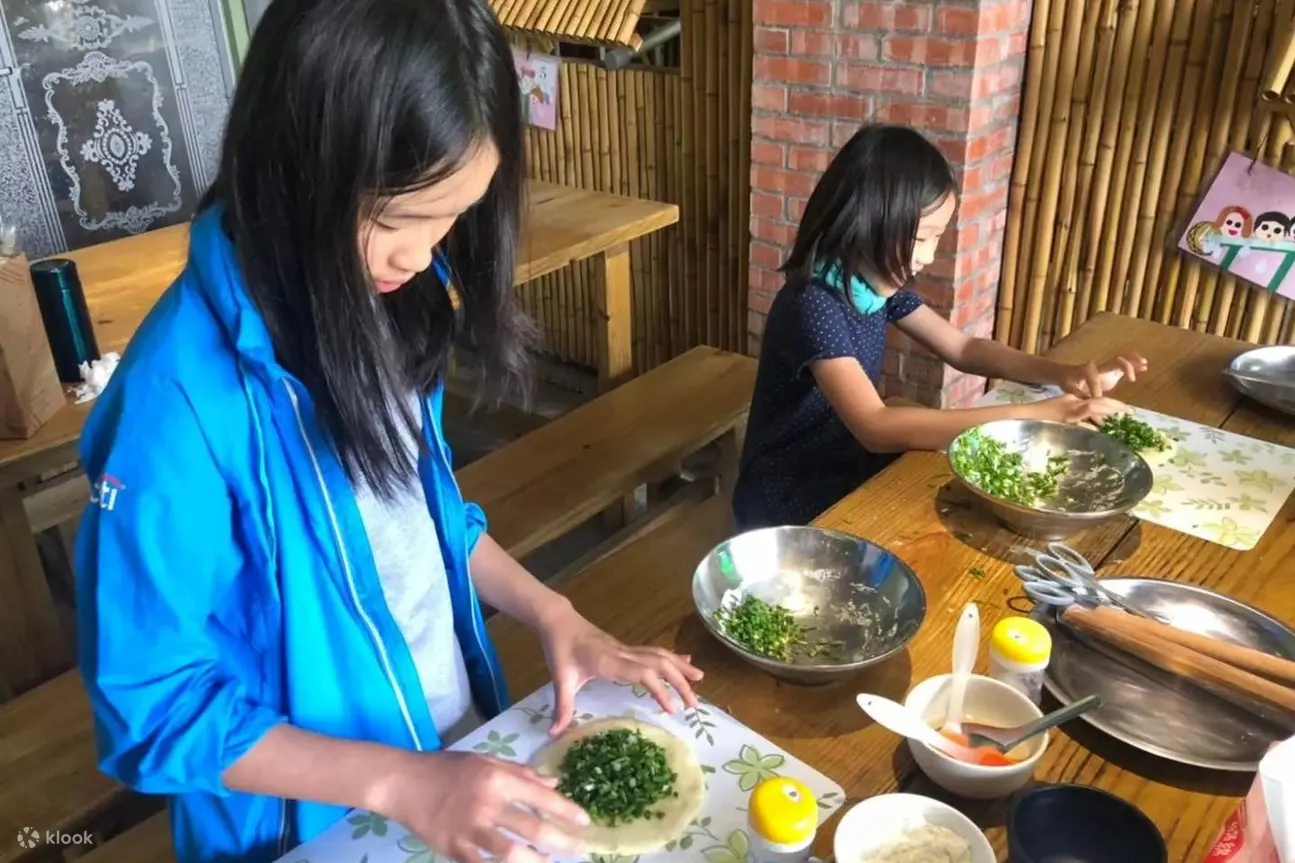 两个女孩正在体验制作葱油饼