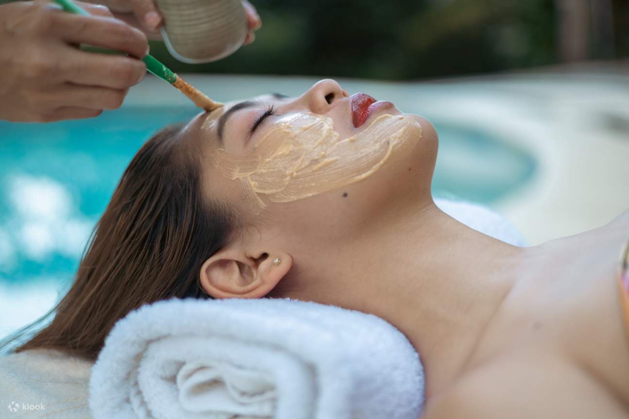 Женщине делают массаж лица с нанесением косметического продукта в Ilaya Retreat Spa.