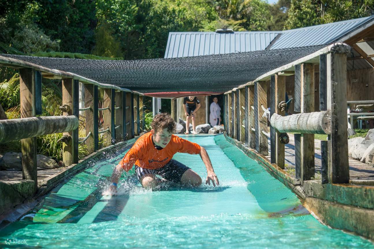 Un homme s'amuse sur le toboggan aquatique de Waimarino Adventure Park