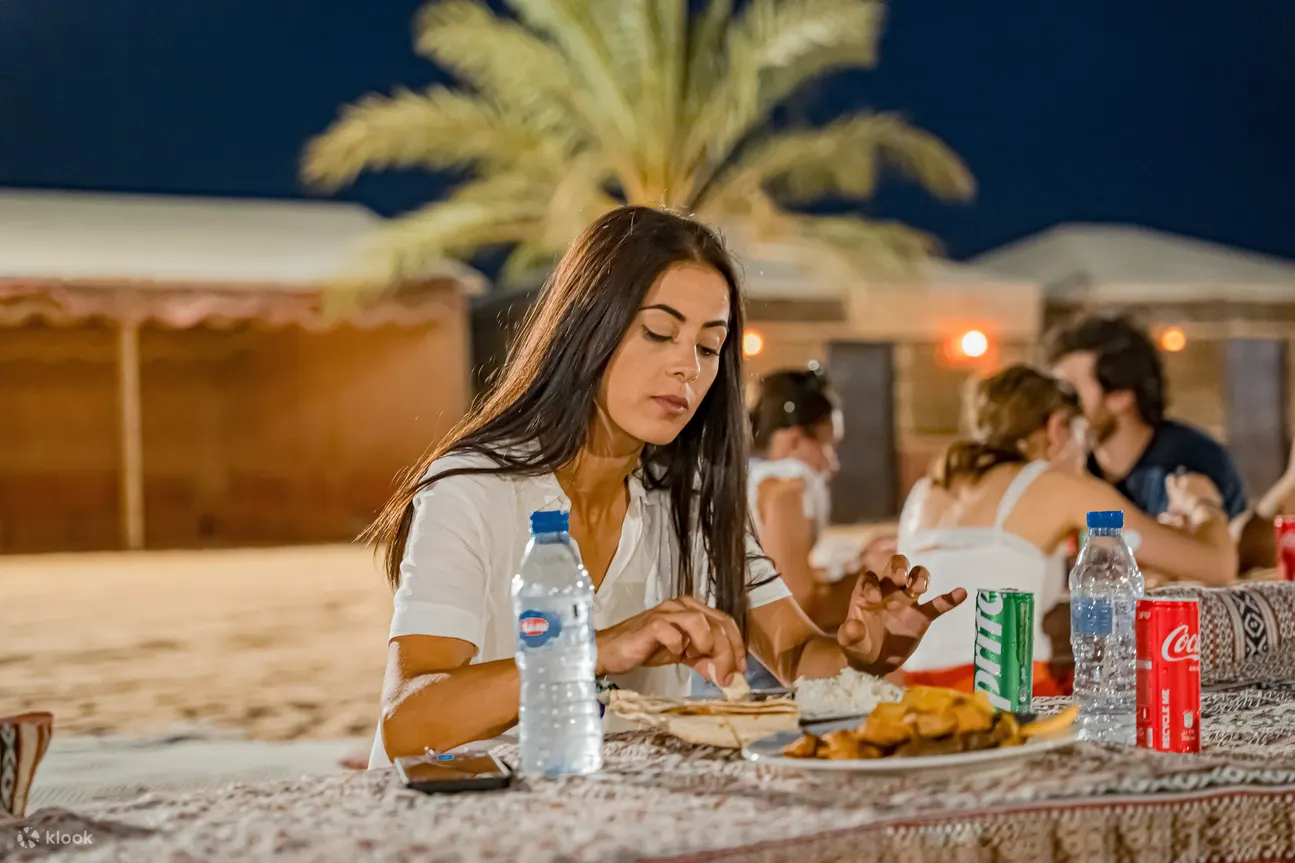 A woman enjoying a meal in the desert of Dubai