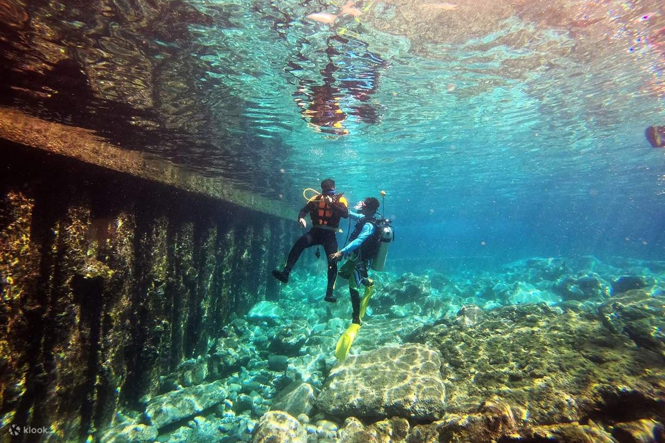 Instructor que guía individualmente a los alumnos en la zona de aguas poco profundas.