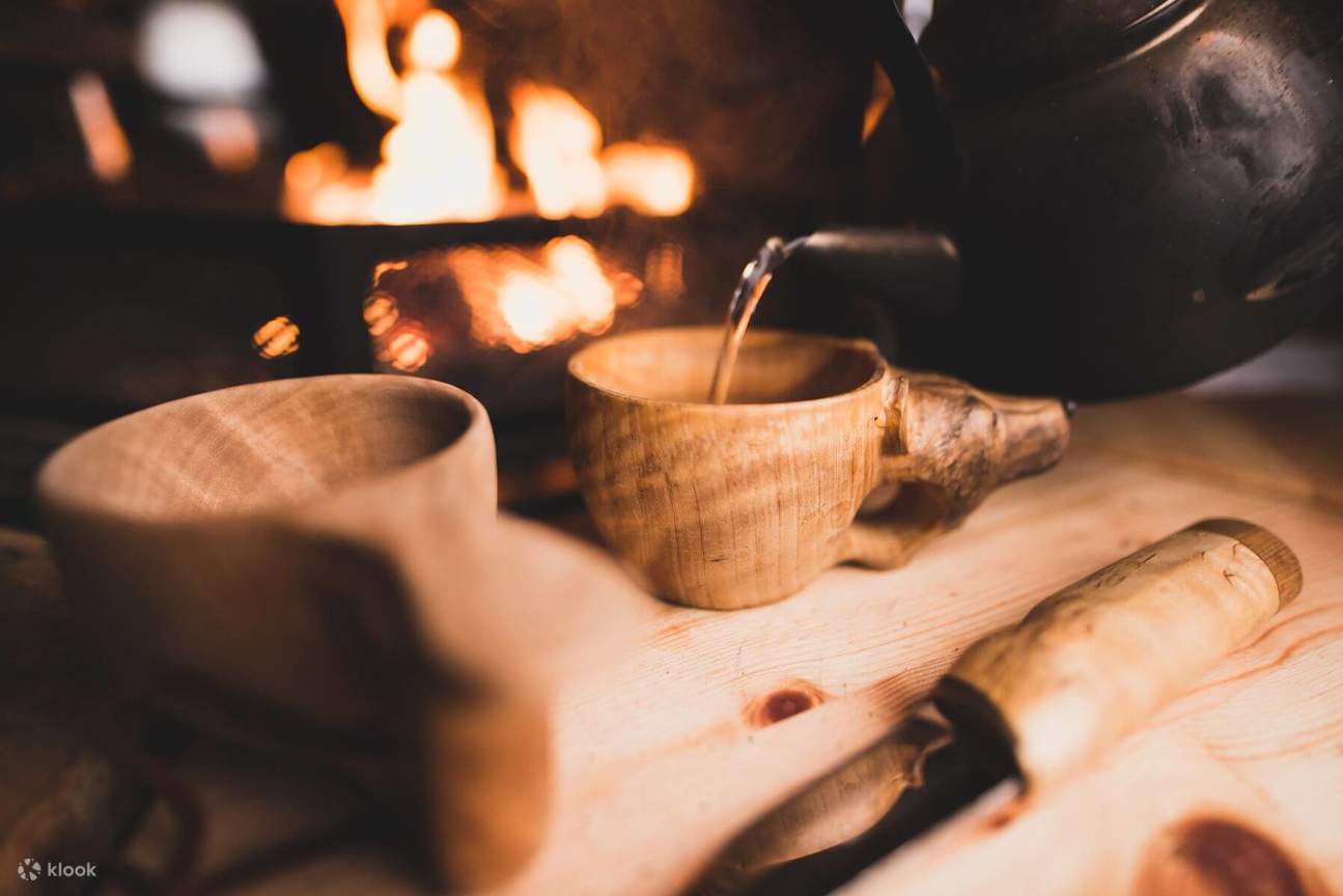 手作りの木製カップで伝統的なフィンランドの飲み物を飲みながら、暖炉のそばで暖まりましょう。