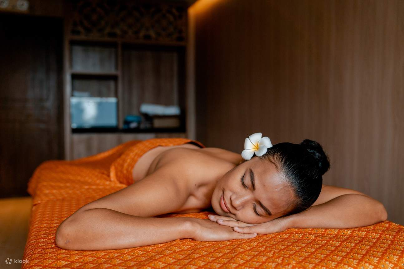 Женщина отдыхает на оранжевой кровати с цветком в волосах