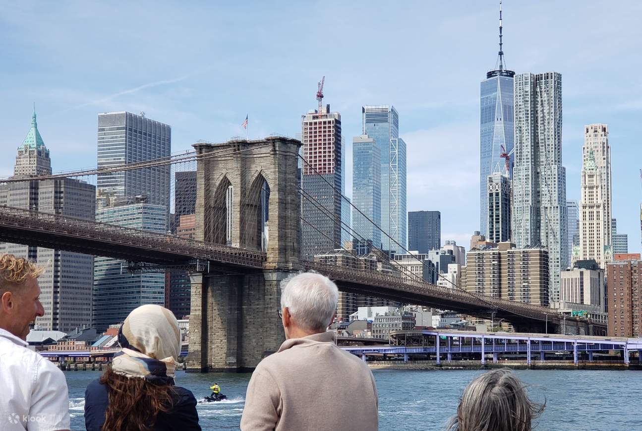 Naviga sotto il Ponte di Brooklyn con lo sfondo dello Skyline di Manhattan