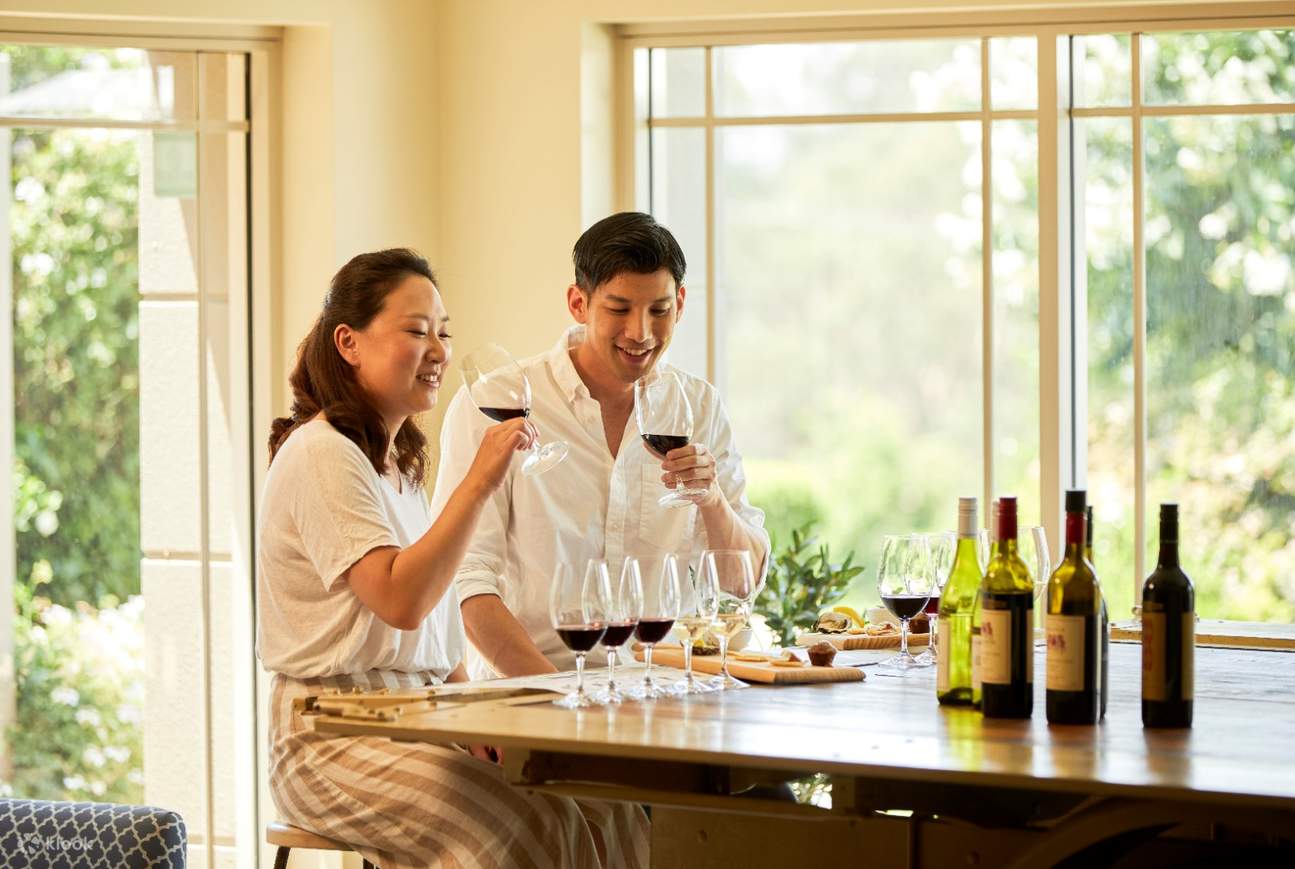 Một cặp đôi đi dạo và uống rượu vang tại vườn nho