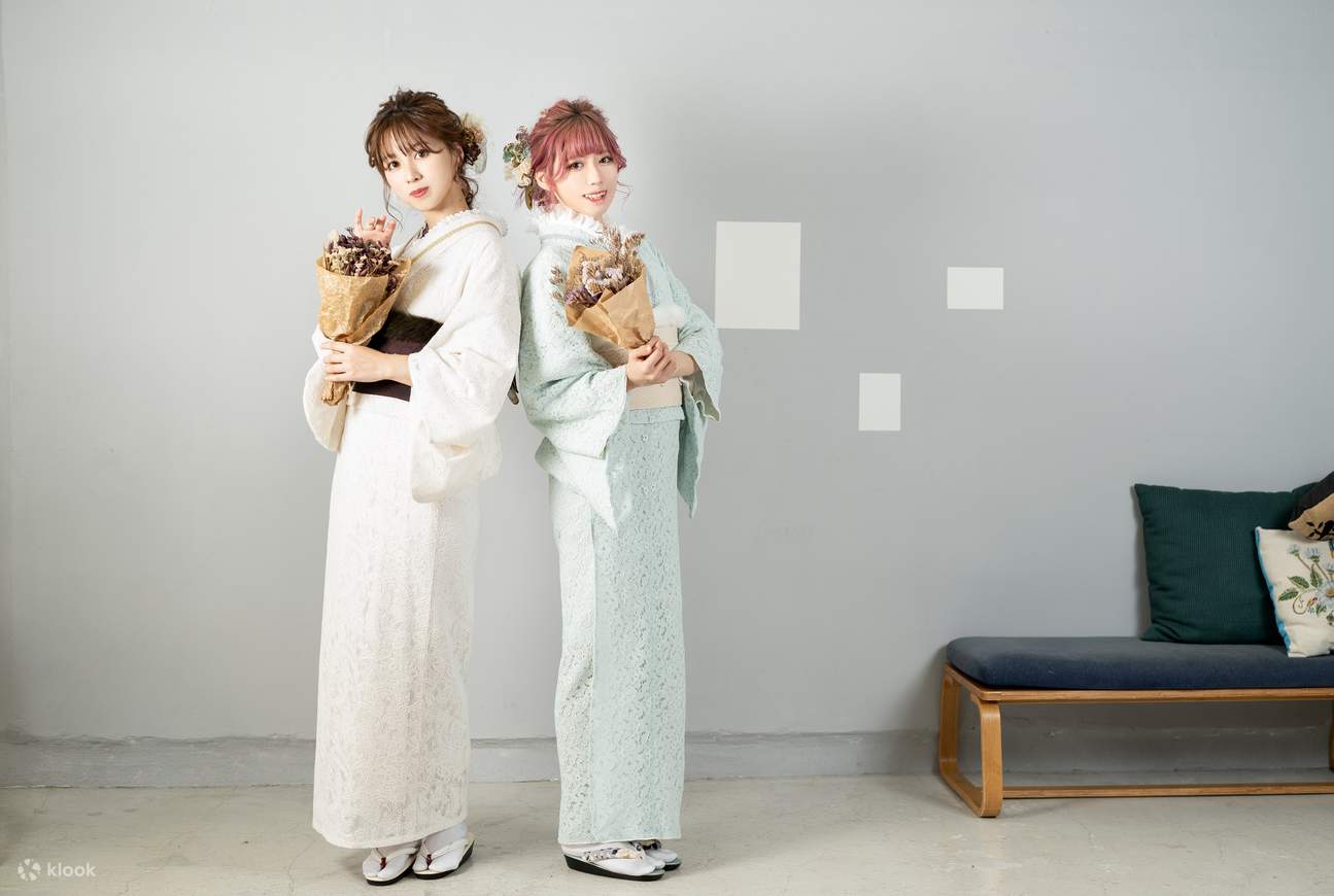 two tourists pose for a photo while wearing a kimono